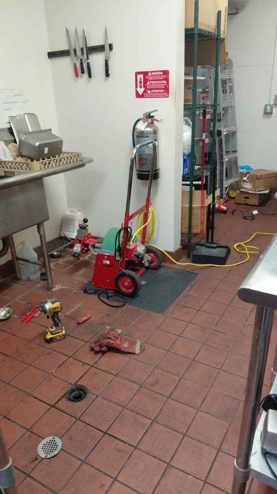 Drain-cleaning machine and plumbing tools at a commercial kitchen jobsite