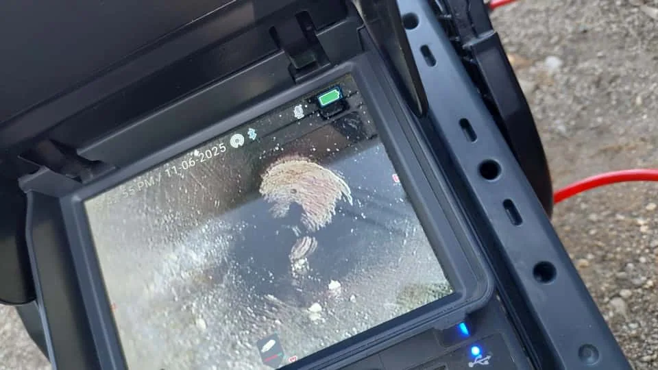 Sewer inspection camera monitor showing the interior of a drain line